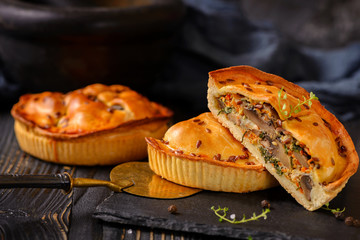 Meat mini pie on the wooden board on table background, closeup with copy space, rustic style