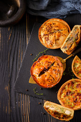Meat mini pie on the wooden board on table background, closeup with copy space, rustic style