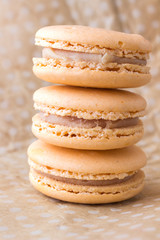 Three macaroni cake  on a beige polka dot background. Top view.