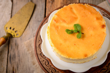 Homemade round cheesecake with mint for dessert - healthy organic summer dessert pie cheesecake. Country style.