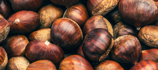 Roasted chestnuts served in chestnut pan on an old table