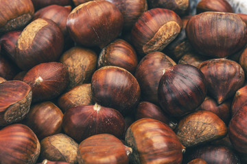 Roasted chestnuts served in chestnut pan on an old table