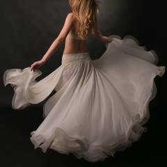 Belly dancer in a long ivory skirt