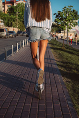 Beautiful girl riding a scooter down the street