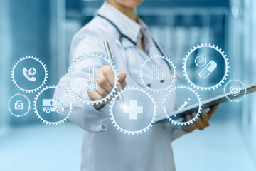 A doctor is operating with cogwheels mechanism containing the medical symbols inside while making notes.