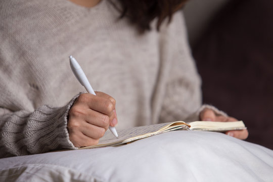 Mujer morena escribiendo a mano una carta