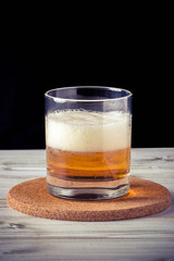 glass of beer, wooden table, foam, black background