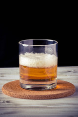 glass of beer, wooden table, foam, black background