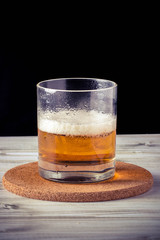 glass of beer, wooden table, foam, black background