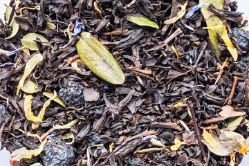 texture of dry herbal tea with berries and leaves of blueberries and cranberries, closeup drink abstraction background