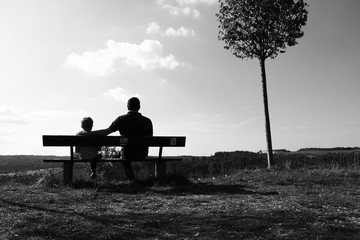 Vater und Sohn genießen die Sonnenstrahlen im Herbst