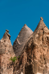 Fototapeta na wymiar A detail from the structure of Cappadocia. Impressive fairy chimneys of sandstone in the canyon near Cavusin village, Cappadocia, Nevsehir Province in the Central Anatolia Region of Turkey. Clear sky.