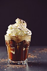 Mochaccino with whipped cream and chocolate isolated on dark