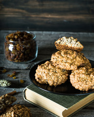 Homemade oatmeal cookies on wooden board on old table background. Healthy Food Snack Concept. Milk and cookies. Still life of food. Christmas cookies. Healthy food. Breakfast concept. raisins