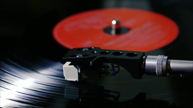 Panning shot of black vintage vinyl record spinning on a turntable slow motion