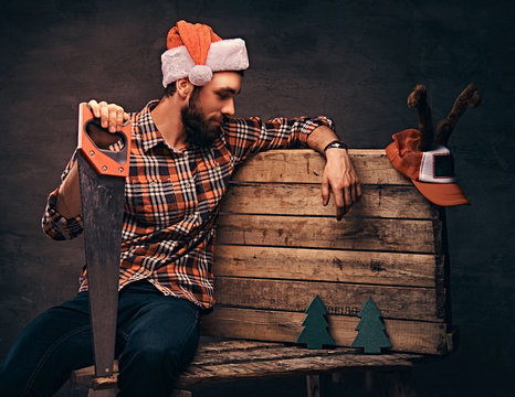 Carpenter Wearing Decorated Santa Hat Sitting On A Wooden Palette.