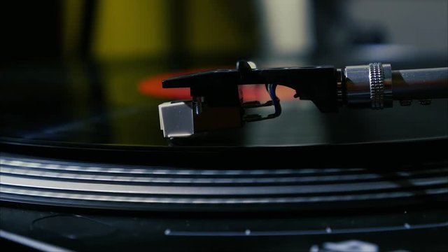A needle is put down on the spinning black vinyl record on the turntable