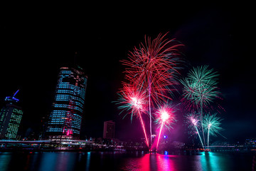 Fireworks nightscape in front of colourful brisbane city lights