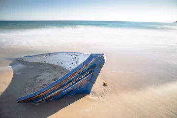 Photo sur Plexiglas Plage de Bolonia, Tarifa, Espagne Ruined patera or dinghy used to transport illegal immigrants Bolonia beach Andalusia Spain 