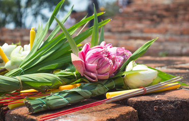incense candle and pink lotus for pray on ancient brick wall temple