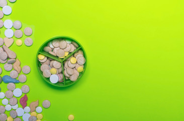 Assorted pharmaceutical medicine pills, tablets and capsules on green background. Copy space for text