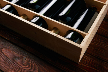 Six wine bottles collection in wooden box on wood table backgrou