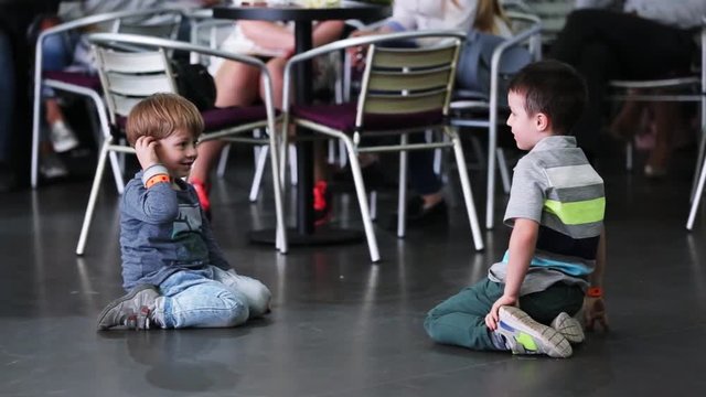 Two funny friends boy play sitting in a cafe smile feel happy party child cute restaurant caucasian family glass kid delicious innocence indoor close up