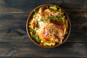 Whole baked chicken with mushrooms and potatoes close-up in a baking dish on a table. horizontal top view from above. Baked turkey. Christmas dish. Thanksgiving Day. Still life of food.