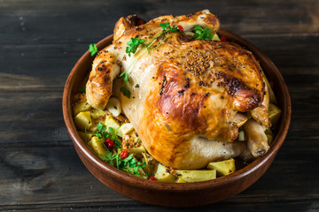 Whole baked chicken with mushrooms and potatoes close-up in a baking dish on a table. horizontal top view from above. Baked turkey. Christmas dish. Thanksgiving Day. Still life of food.