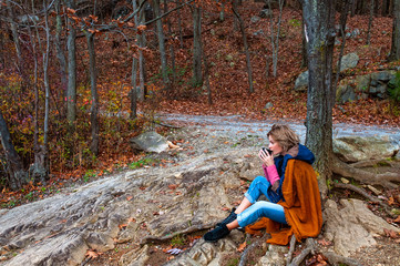 Beautiful woman drinking coffee in autumn park