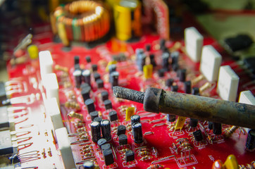 Electronic manufacturing and repair concept - soldering iron and microcircuit next to it - close up studio shot