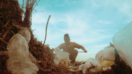 man homeless dump in a landfill homeless looking for food among the garbage. social concept problem poverty hunger man. problem of poverty and lifestyle social inequality concept