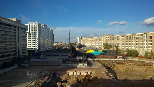 View of the construction site with business centers on the sides and the Ostankino television tower in the distance and car traffic