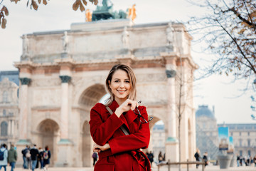 Style redhead girl in red coat and bag at parisian street in autumn season time