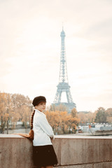 Style young girl with long hair at parisian street. Eiffel tower tower on background