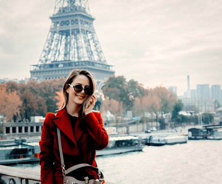 Style redhead girl in red coat make a photo on parisian street in autumn season time. Eiffel tower on background