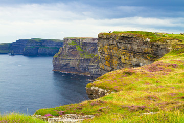 Photo of beautiful scenic sea and mountain landscape. Cliffs of Moher, west coast of Ireland, Atlantic ocean. View of ocean scenery