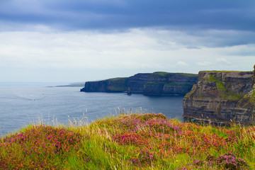 Photo of beautiful scenic sea and mountain landscape. Cliffs of Moher, west coast of Ireland, Atlantic ocean. View of ocean scenery