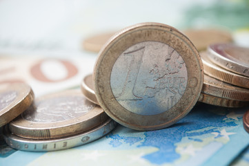 closeup of coins pile and banknotes in euro money