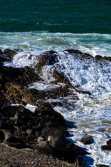 Pacific Ocean waves crashing into a rock formation at Mugu Rock in Malibu, California