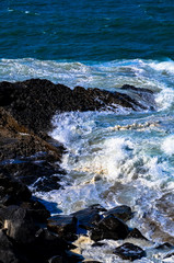 Pacific Ocean waves crashing into a rock formation at Mugu Rock in Malibu, California