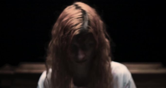 Scary girl obsessed by devil looking to the camera / exorcism concept
