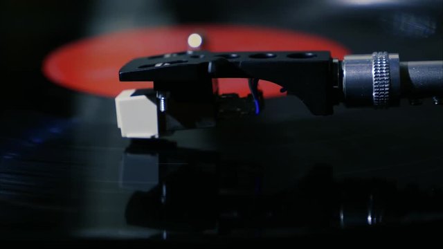 A black vintage vinyl record spins on a turntable with needle