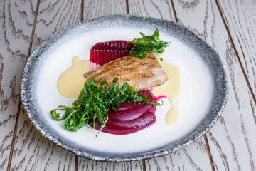 Delicious mediterranean seafood. Fish with green salad on a white plate