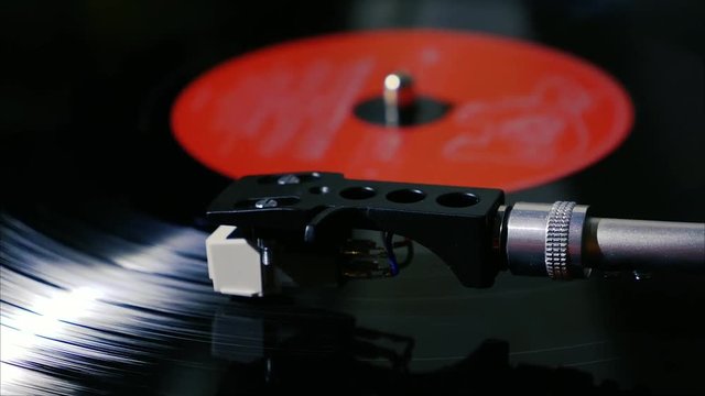 Panning shot of black vintage vinyl record spinning on a turntable