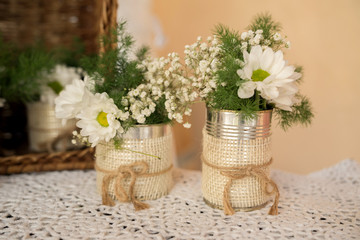 White flower inside a glass jar with woody background