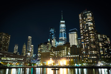 A picture of the NYC Skyline and a fall evening near the harbor on the west side highway pier. Touristic sites of downtown Manhattan with the WTC in direct view 