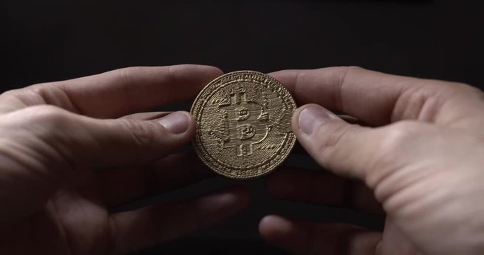 Two hands holding Crypto currency Gold Bitcoin - BTC - Bit Coin. Macro shots.
