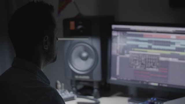 Producer,  Sound engineer,  musician checking the sound mix in his studio and reacting to the music groove