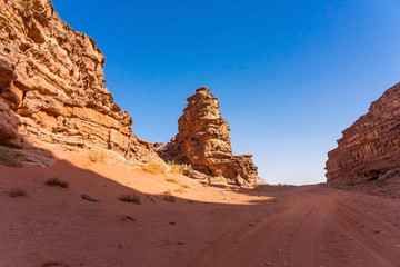 Fototapeta na wymiar Red mountains of Wadi Rum desert in Jordan. Wadi Rum also known as The Valley of the Moon is a valley cut into the sandstone and granite rock in southern Jordan to the east of Aqaba